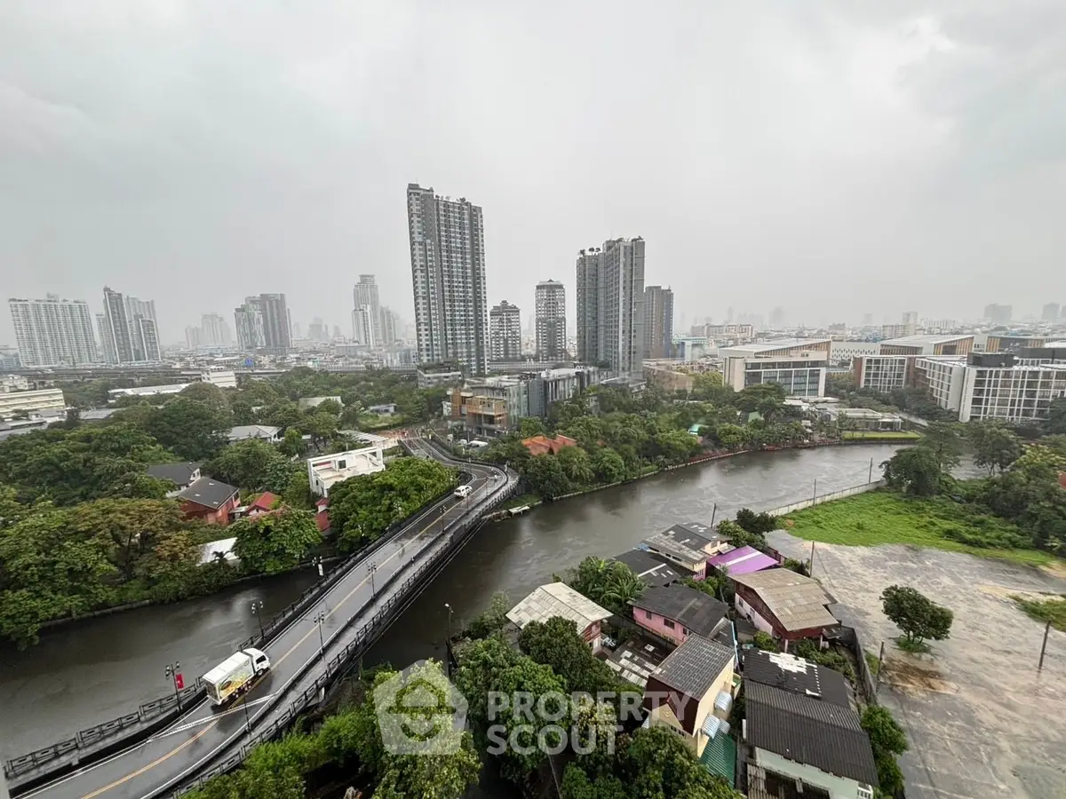 Stunning cityscape view with river and high-rise buildings under a cloudy sky, perfect for urban living.