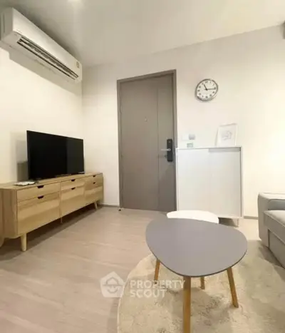 Modern living room with minimalist furniture and wall-mounted air conditioner.