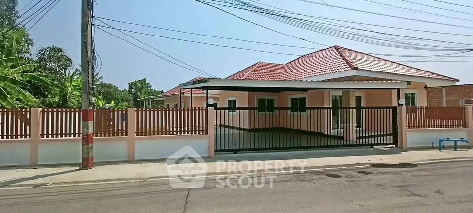 Charming single-story house with red roof and fenced yard in a serene neighborhood.