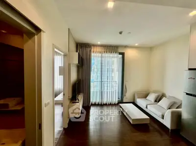 Modern living room with sleek furniture and balcony view in a stylish apartment.