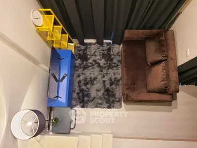 Modern living room with plush brown sofa, stylish blue and yellow shelving, and cozy gray rug.