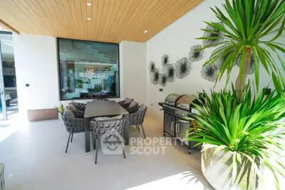 Luxurious outdoor dining area with modern furniture and lush greenery, perfect for entertaining guests.