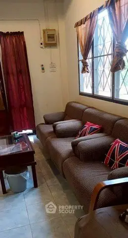 Cozy living room with comfortable sofa and large window, perfect for relaxation.