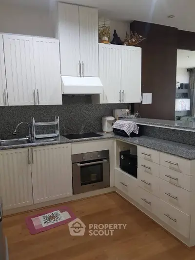 Modern kitchen with sleek white cabinetry and built-in oven
