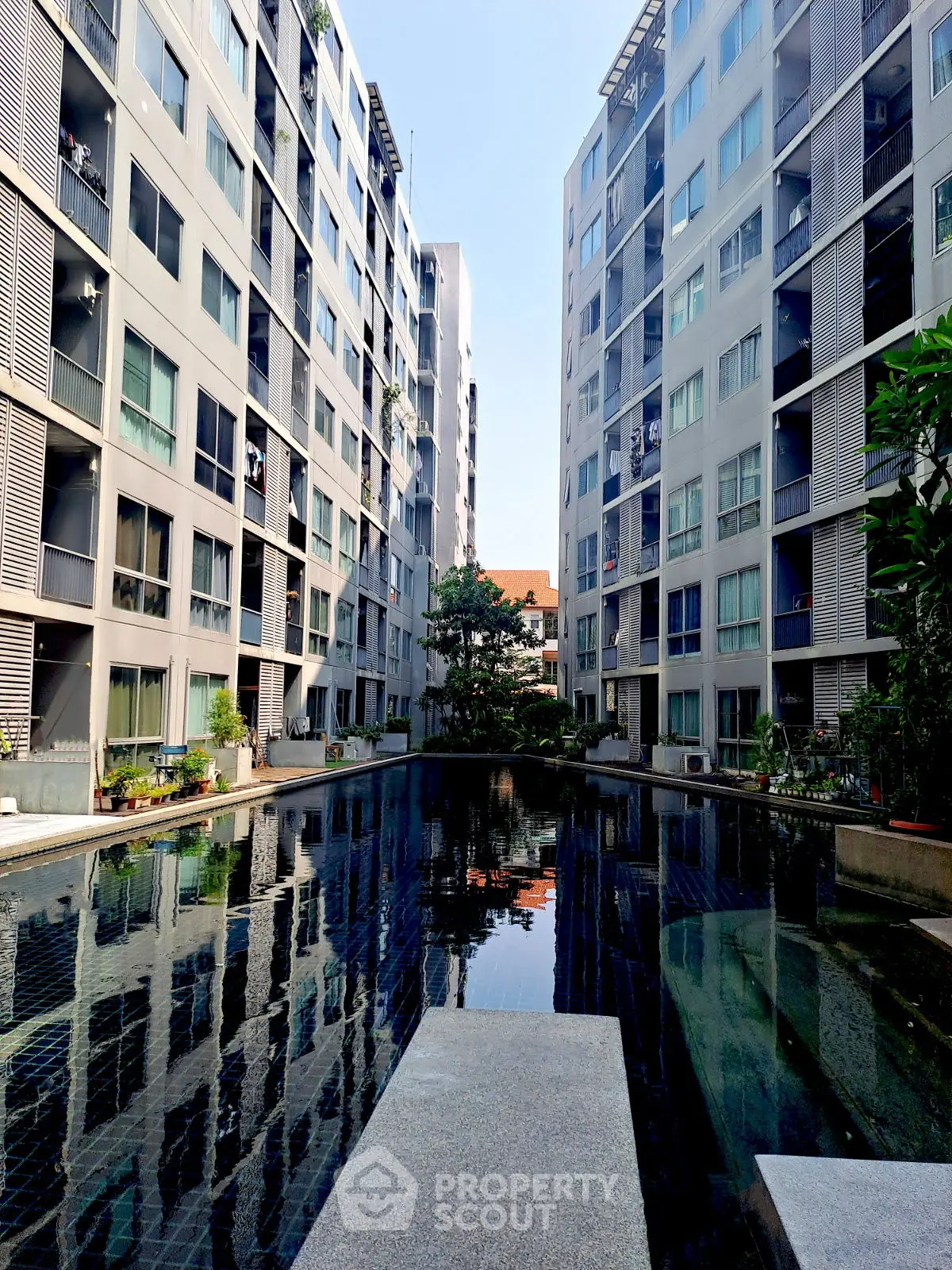 Modern apartment complex with central pool and contemporary architecture