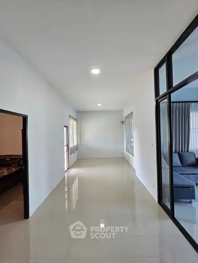 Spacious modern living area with sleek tile flooring and large windows for natural light.