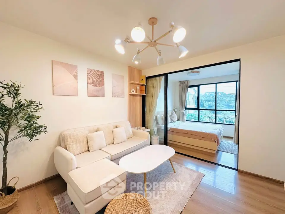 Modern living room with cozy sofa and elegant bedroom view, featuring stylish decor and natural light.