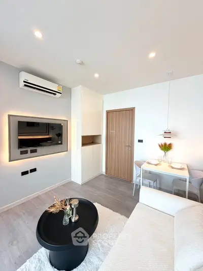 Modern living room with sleek design and cozy dining area, featuring ambient lighting and stylish decor.
