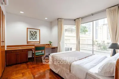 Spacious bedroom with large windows and elegant wooden flooring