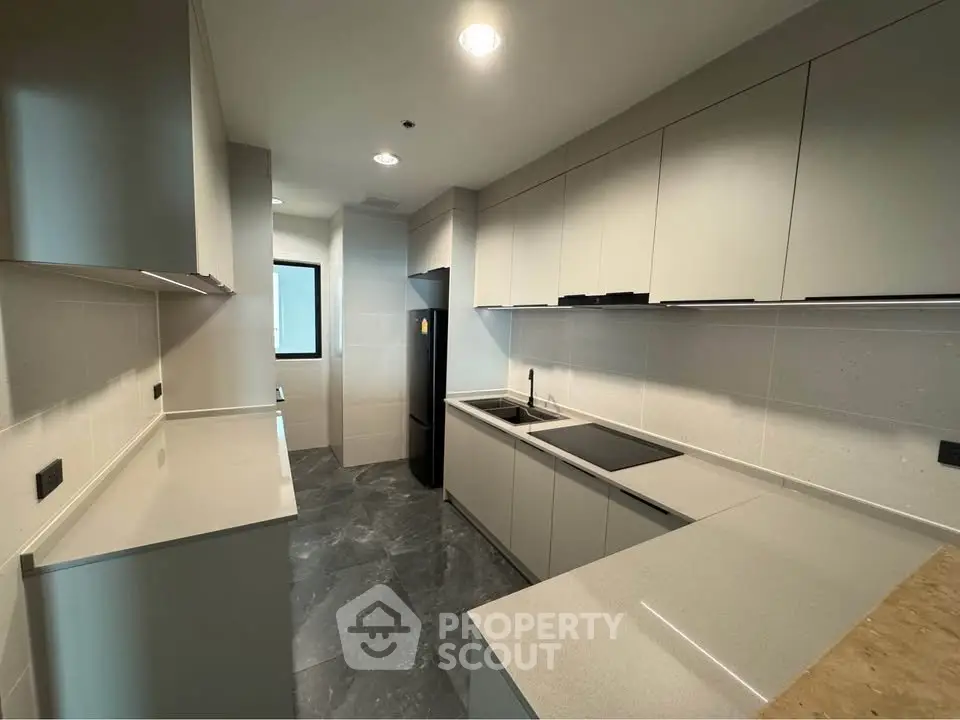 Modern kitchen with sleek cabinetry and integrated appliances in a contemporary apartment.