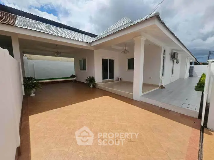 Spacious modern home exterior with covered patio and tiled roof, perfect for outdoor living.