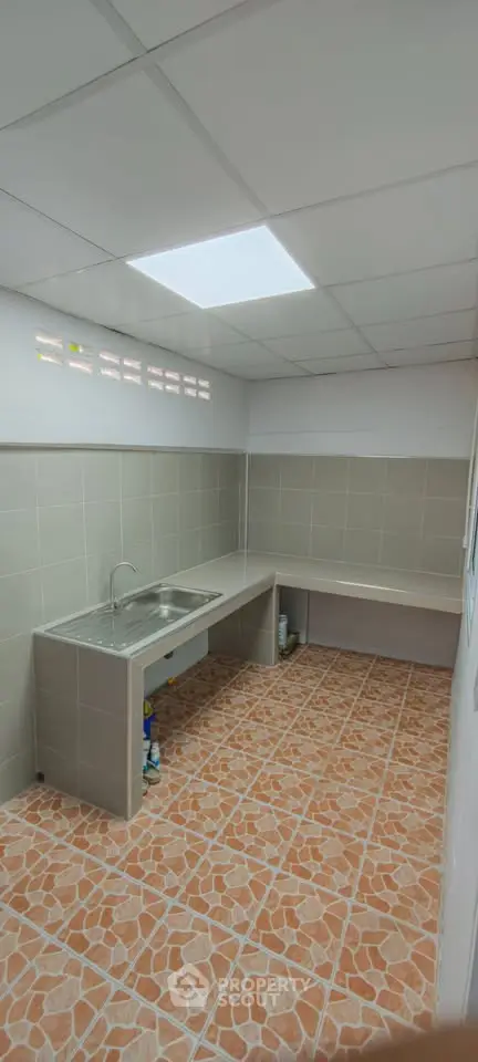 Spacious tiled kitchen with modern sink and ample counter space