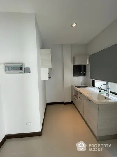 Modern kitchen with sleek cabinetry and large window for natural light