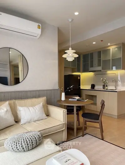Modern living room with open kitchen, featuring stylish furniture and elegant decor.