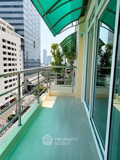 Spacious balcony with city view and modern glass railing in urban apartment