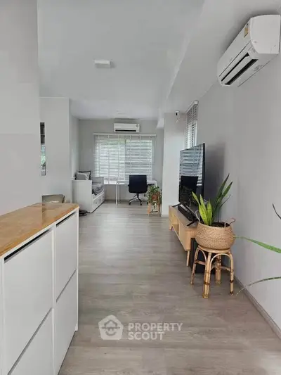 Modern living room with sleek design, featuring air conditioning and stylish decor, perfect for comfortable living.