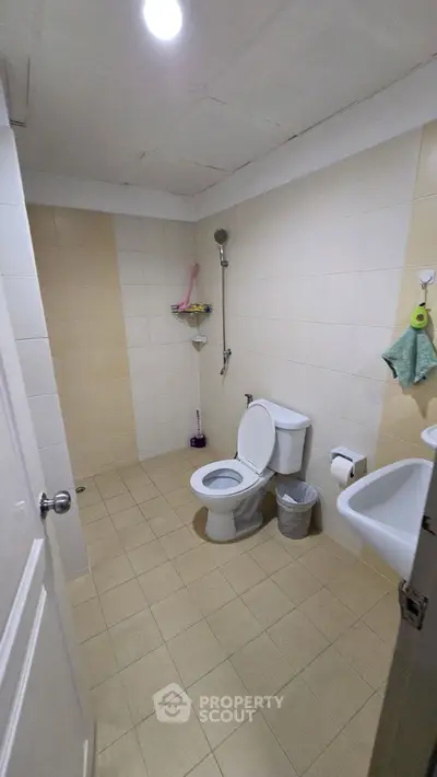 Spacious bathroom with modern fixtures and tiled flooring in a contemporary home.
