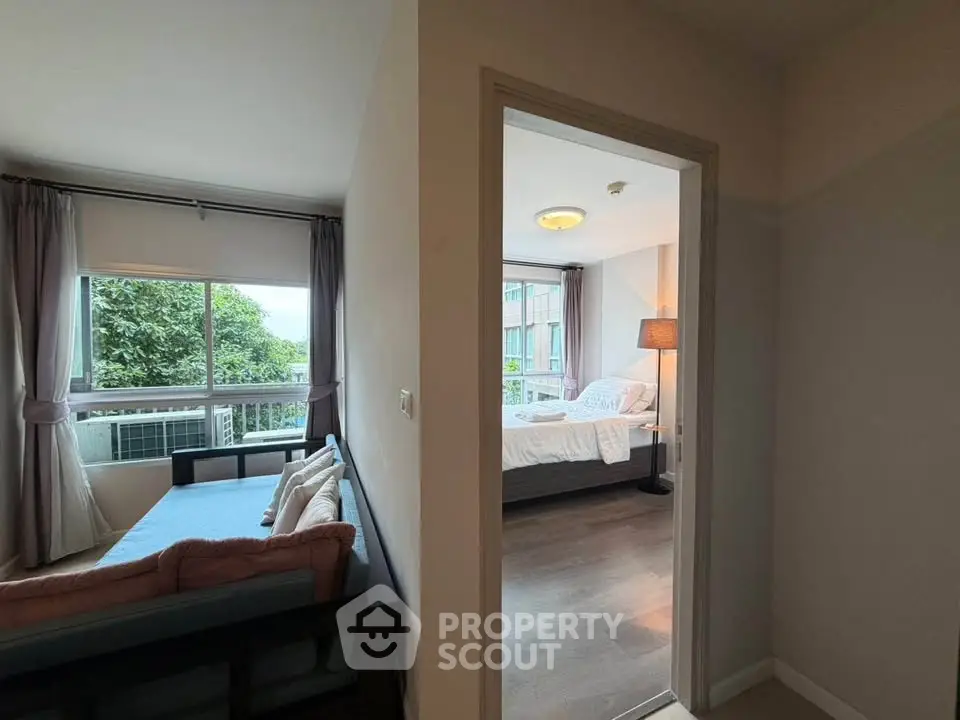 Spacious apartment with cozy living room and bright bedroom, featuring large windows and modern decor.