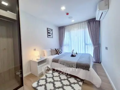 Modern bedroom with stylish decor, large window, and cozy ambiance in a contemporary apartment.