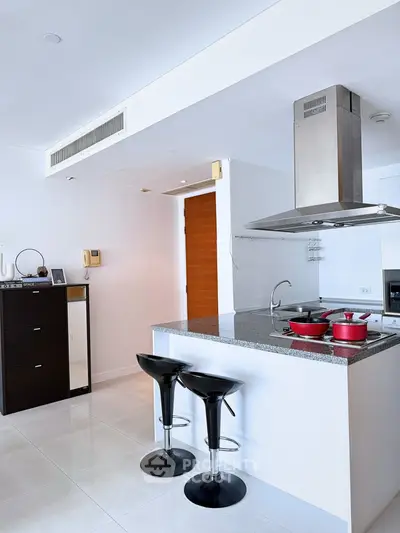 Modern kitchen with sleek island and bar stools in a stylish apartment
