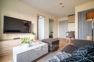 Spacious modern living room with ample natural light, sleek furniture, and a seamless transition to an open kitchen area, perfect for entertaining and relaxation.