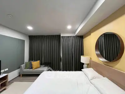 Modern bedroom with cozy decor and stylish furnishings, featuring a large bed and elegant curtains.