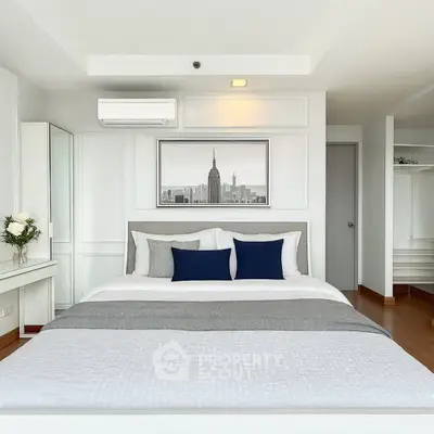 Elegant bedroom with modern decor and cityscape artwork, featuring a cozy bed and stylish furnishings.
