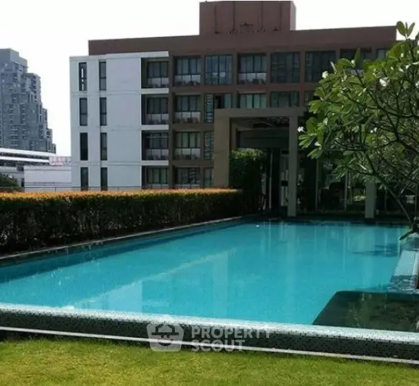 Luxurious apartment complex with a stunning outdoor pool and lush greenery.