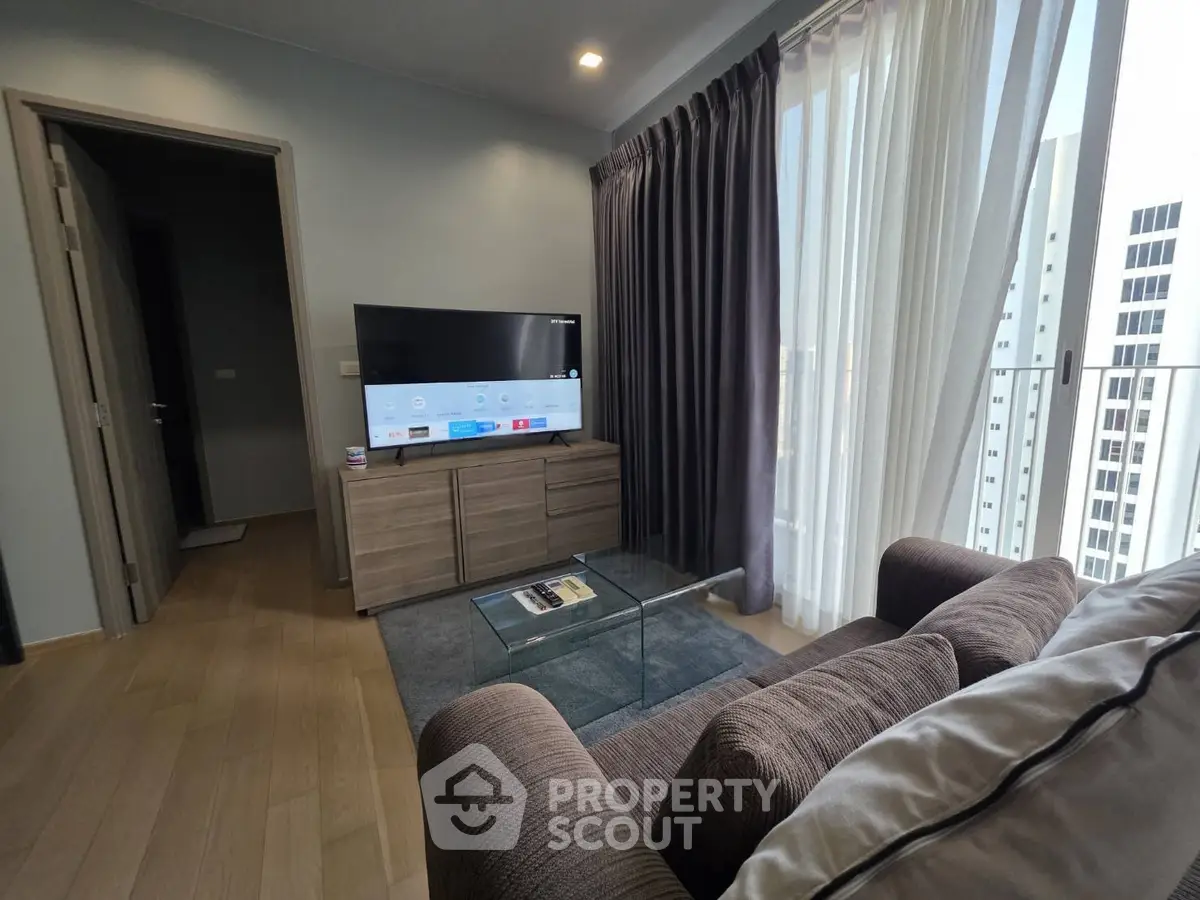 Modern living room with sleek furniture and large windows offering city views