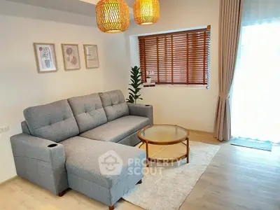 Stylish living room with modern gray sofa, wooden blinds, and chic decor accents.