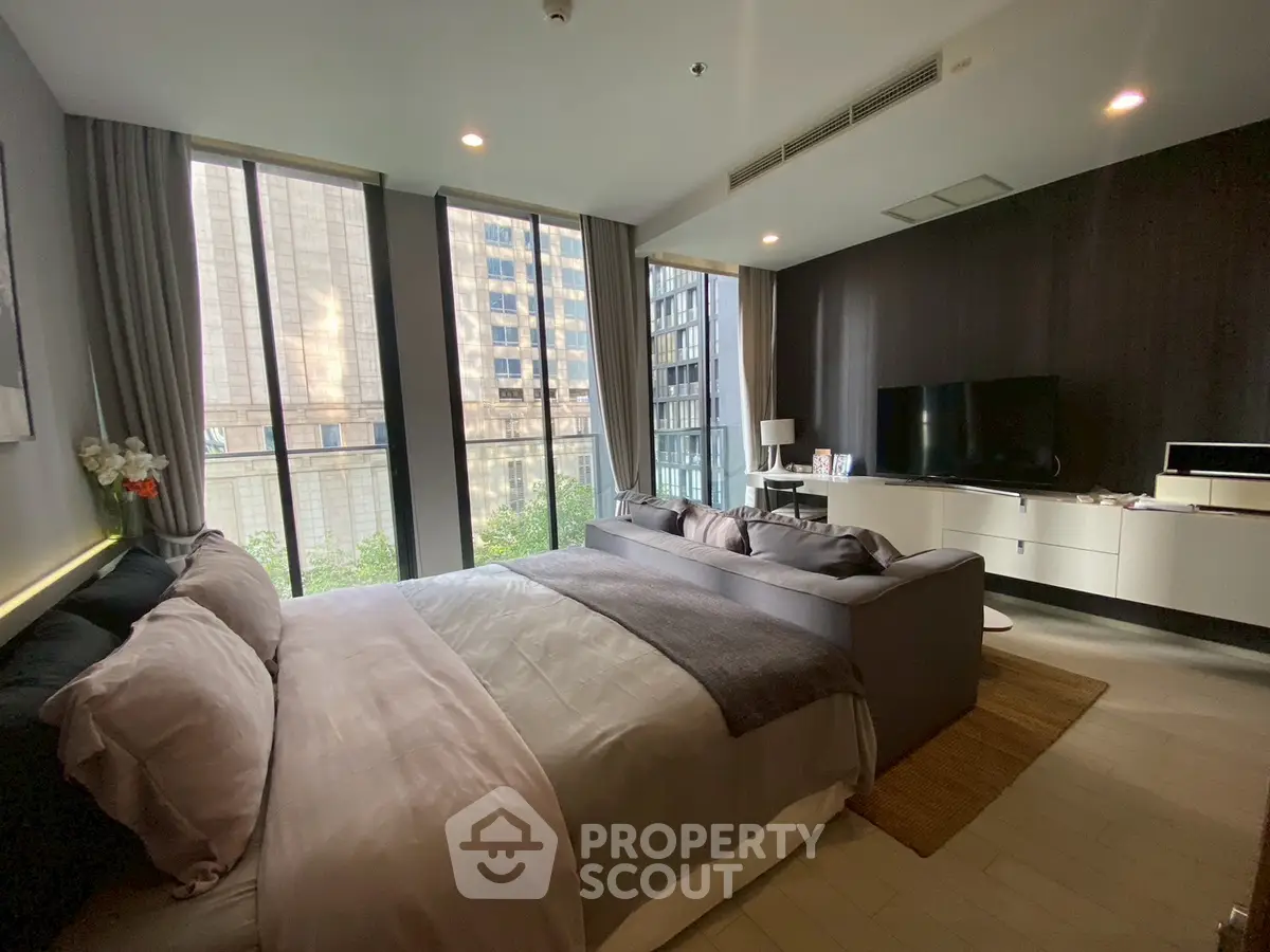 Luxurious bedroom with city view, modern decor, and spacious layout.