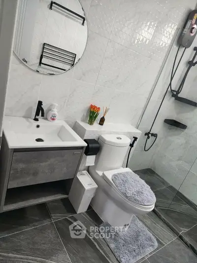 Modern bathroom with sleek fixtures and stylish decor, featuring a glass shower and elegant vanity.