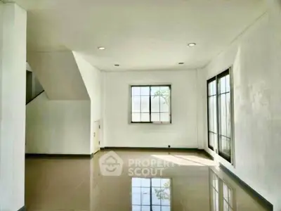 Spacious empty living room with large windows and glossy floors