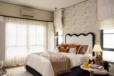 Charming bedroom with stylish decor and cozy ambiance, featuring plush bedding and elegant wallpaper.