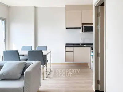 Modern open-plan living room and kitchen with sleek furniture and natural light.