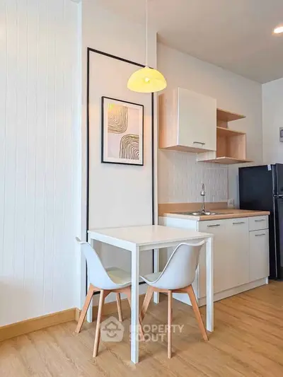 Modern kitchen with sleek white cabinets and cozy dining area