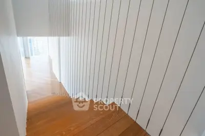 Modern staircase with sleek wooden steps and minimalist railing design in a contemporary home.