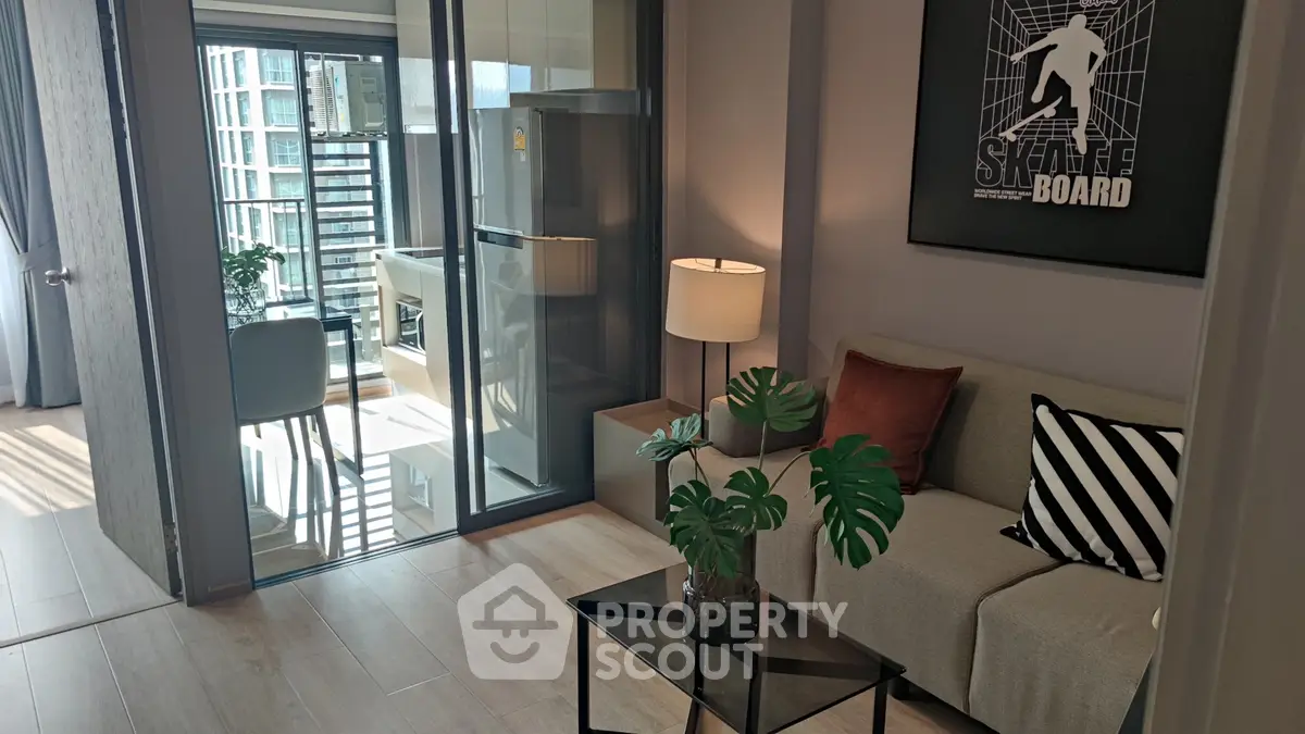 Modern living room with stylish decor and balcony view in urban apartment.