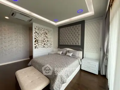 Luxurious bedroom with elegant decor and modern lighting, featuring a plush bed and stylish wall design.