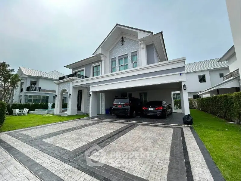 Luxurious two-story house with spacious driveway and manicured lawn in upscale neighborhood.