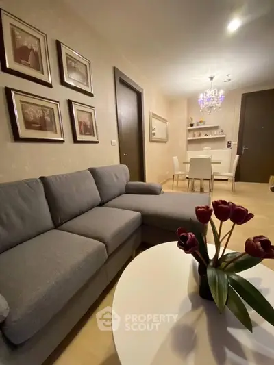 Stylish living room with modern gray sofa and elegant dining area, perfect for cozy gatherings.