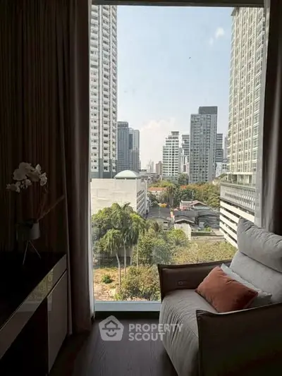 Luxurious high-rise apartment with stunning city view from cozy living room.