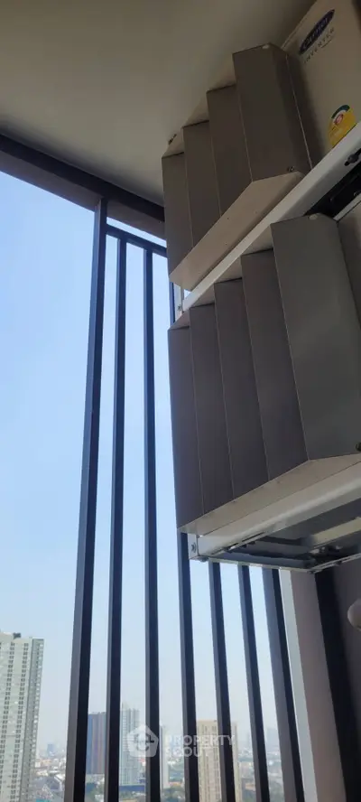 Modern high-rise balcony with city view and air conditioning units.