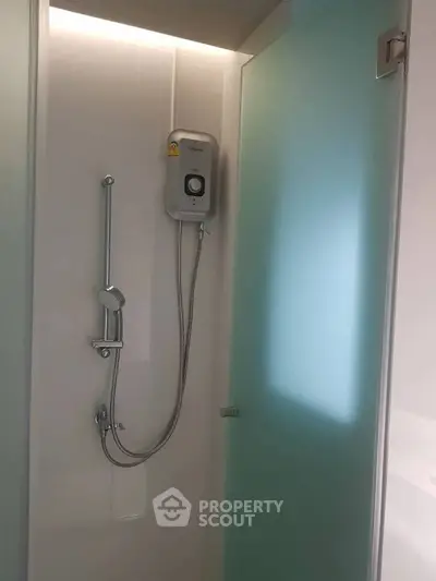 Modern bathroom shower area with frosted glass door and sleek fixtures.
