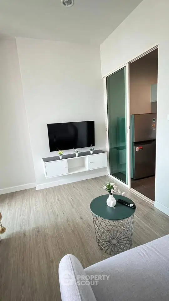 Modern living room with sleek TV setup and stylish decor in a contemporary apartment.