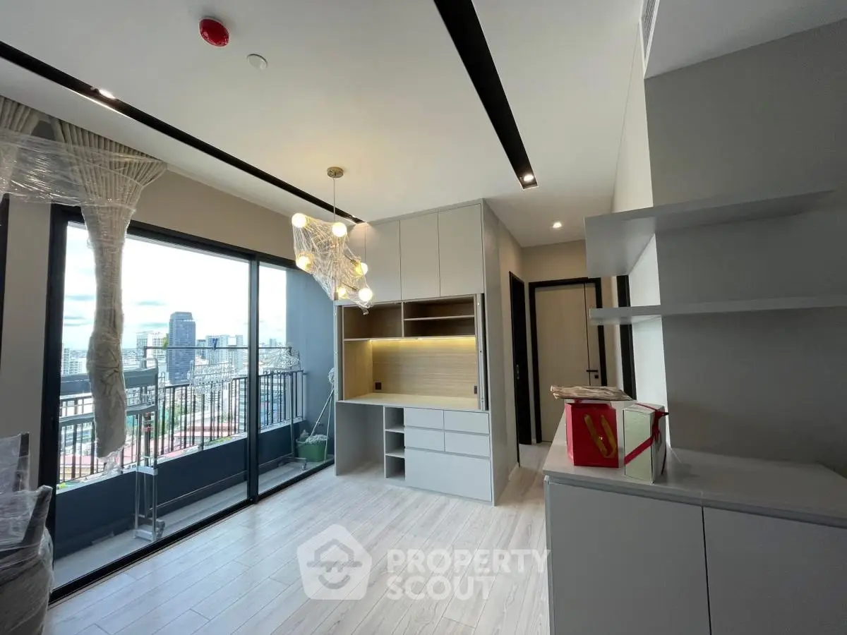 Modern living room with balcony and city view, featuring sleek design and ample natural light.