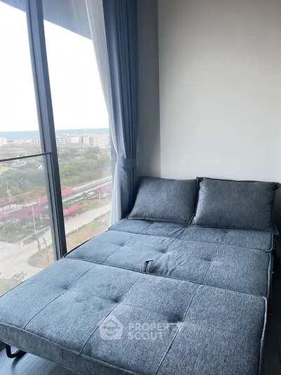 Cozy bedroom with a modern bed and large window offering a scenic view, perfect for relaxation.