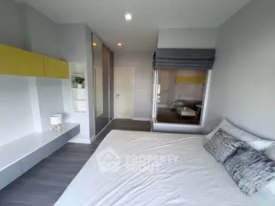 Modern bedroom with sleek design and large window overlooking living area, featuring stylish decor and ample storage.