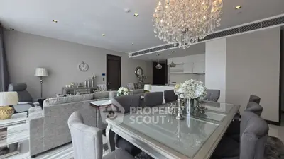 Luxurious open-plan living and dining area with elegant chandelier and modern decor.