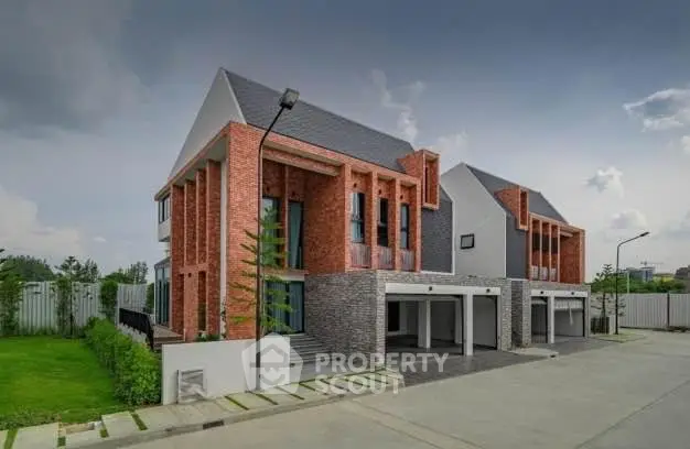 Modern brick townhouse with spacious garage and lush green surroundings.